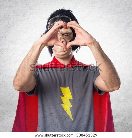 Superhero monkey man making a heart with his hands on textured background