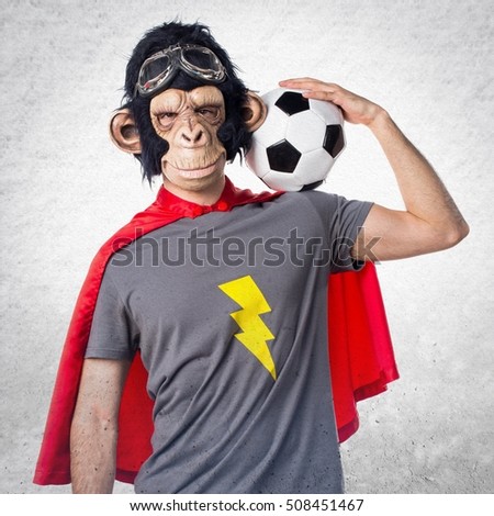 Superhero monkey man holding a soccer ball on textured background