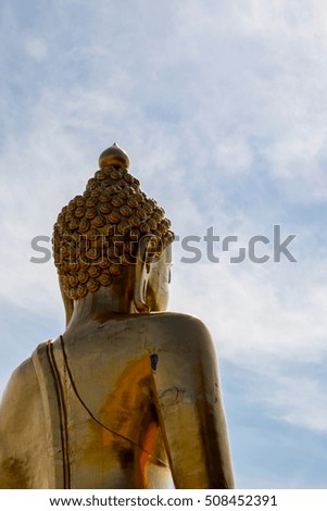 Golden Buddha statue in Thailand, on blue sky background
