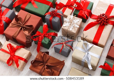 Lots of Gift boxes on white background. Presents in craft and colored paper decorated with red satin ribbon bows. Christmas and other holidays concept.