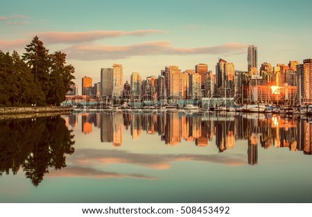 Beautiful view of Vancouver skyline with famous Stanley Park in scenic golden evening light at sunset with retro vintage Instagram style pastel toned filter effect in summer, British Columbia, Canada