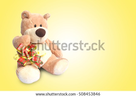 Close up teddy bear with box on yellow background, concept christmas and new year