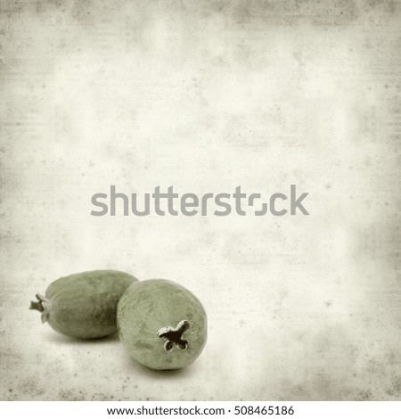 textured old paper background with green feijoa fruit