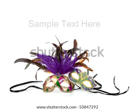 Purple, green and gold mardi gras masks on a white background with copy space