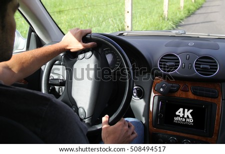 young man driving a car showing on-board screen computer 4k. All screen graphics are made up.