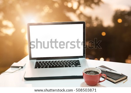Laptop with blank screen on morning sunshine background,A computer laptop and other gadget on work table, empty screen of laptop, vintage effect.