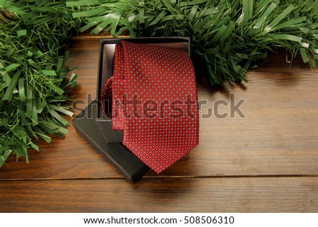 Rolled  Red Tie and Box on Wood with a Decoration