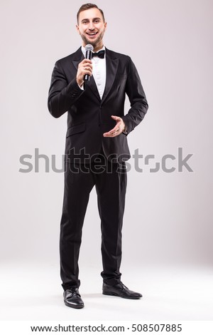 Young Showman presenter with microphone against white background.Showman concept. Royalty-Free Stock Photo #508507885
