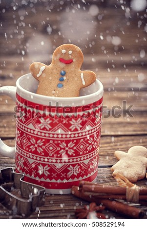 Gingerbread cookie men with mug on wooden background with snow 