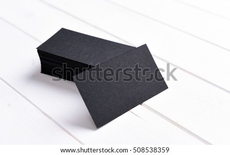 stack of black business cards on a white wooden table