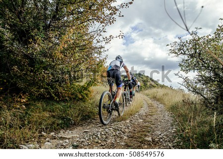 group of cyclists on sports mountainbike riding uphill. Cycling competition Royalty-Free Stock Photo #508549576