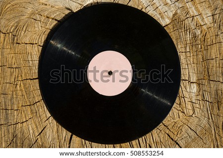 old vinyl disk lies on a wood background