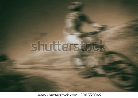 athlete cyclist rides along a dirt road, blurred background