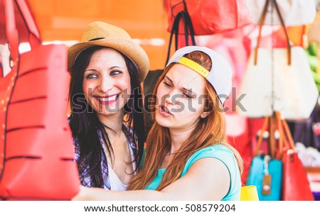 Young cheerful women at flea market buying fashion bags - Best female friends having fun and shopping in the old town center - New trends accessories addiction concept - Vivid color tones editing