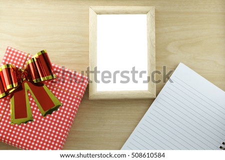 Red gift and wood picture frame on wooden background,concept of Christmas and New Year's Day.