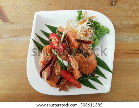 Close up picture of Thai food Fried Shrimp with Tamarind Sauce on white plate with brown wood table ,Popular local food in Phuket,Thailand