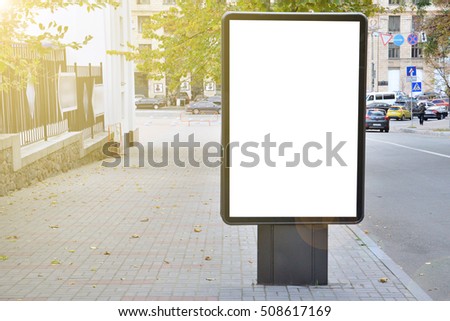 Blank billboard with copy space for your text message or content, outdoors advertising mock up, public information board on city road, flare sun light. Empty Lightbox on urban setting sidelines
