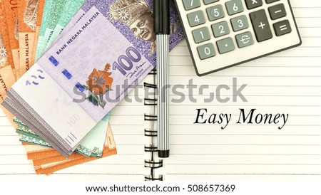 conceptual image with cash, calculator and notepad with word " easy money"