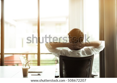 Young businessman relaxing at his desk in office