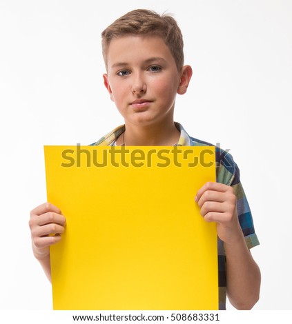 Emotional boy teenager in a plaid shirt with yellow sheet of paper for notes on a white background