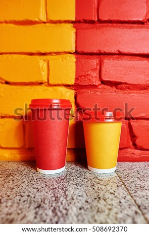 Paper cups on the brick background