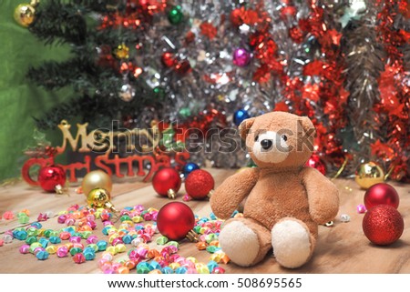 Cute teddy bear sitting with christmas ornaments tree with colorful background 