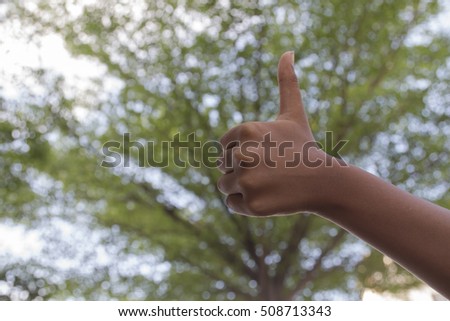 thumbs up on nature green background