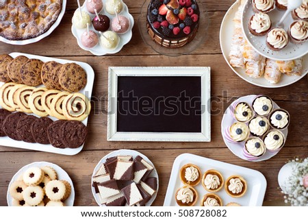 Picture frame and cake, cookies, tarts, cupcakes. Copy space.