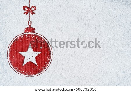 christmas card or new year background made of decorative ball symbol handwritten on snow and red craft paper