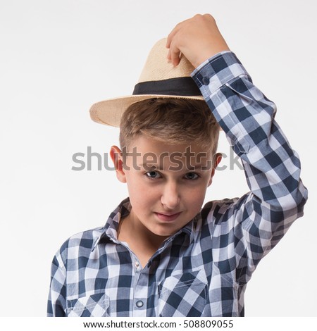 Emotional blond boy checkered shirt and straw hat on a white background