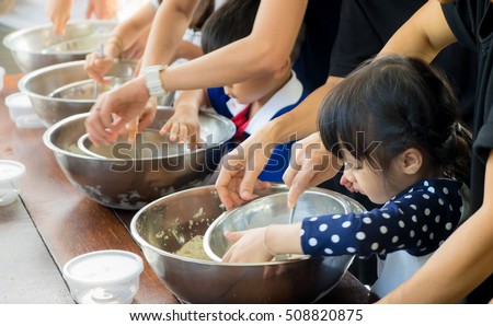 Small kid and family is learning how to make ice cream in a cooking class. Parent are helping children in Baking sweet bakery in a cooking group club activity. Royalty-Free Stock Photo #508820875