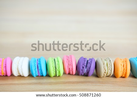 Sweet and colorful, Different kinds of macaroons in stack on light wooden background with blank space,selective focus.