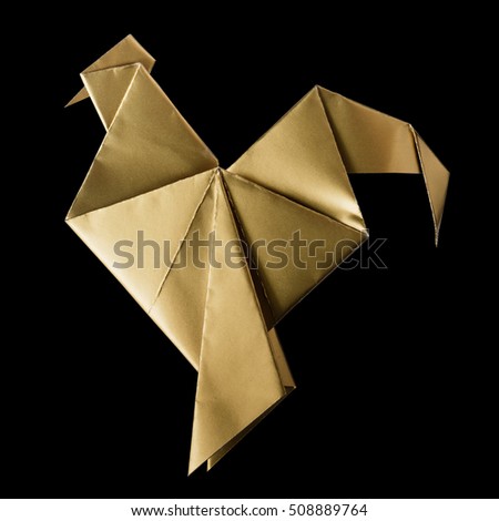 Shiny golden paper folded rooster handmade origami craft on black background isolated