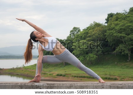 Young asian woman posing yoga, do the exercise for relax, healthy and control mind  in beautiful mountain and lake background, morning time.
