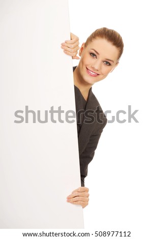 Smiling young businesswoman holding blank banner