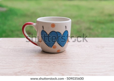 Two heart lovely on coffee cup on a wooden background 

