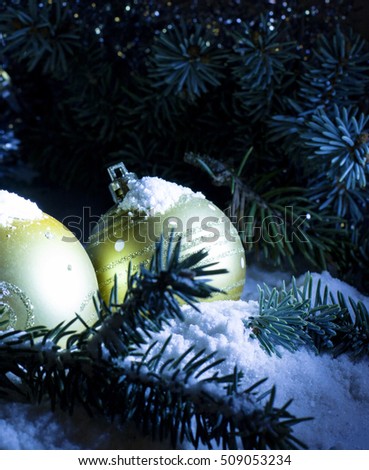 Christmas and New Year`s. Toy gold balls on tree, fir cones and tree branches covered with snow. Greeting card Background concept with holiday tinsel.