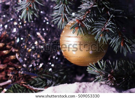 Christmas and New Year`s snowy. Toy red balls on tree, fir cones and tree branches covered with snow. Greeting card Background concept with holiday tinsel.