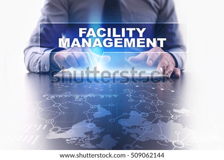 Businessman is using tablet pc, pressing on virtual screen and selecting facility management.