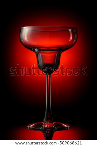 Empty margarita glass on a color background.
