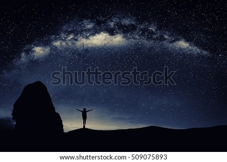 Young man standing under the stars at night. Travel concept. 