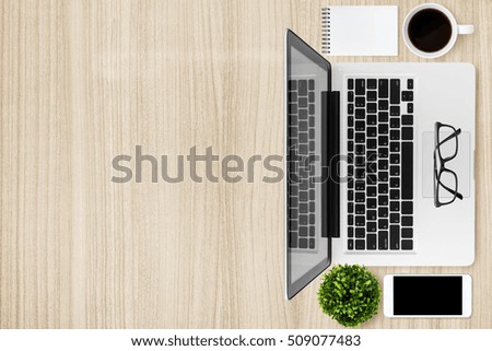 Wood office desk table with laptop, smartphone, cup of coffee and supplies. Top view with copy space, flat lay.