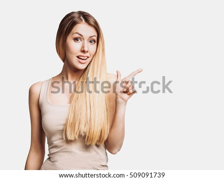 Happy beautiful young girl pointing to product