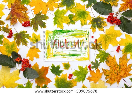 Word autumn, drawn by paints in an album on a white background with autumn leaves and branches of rowan