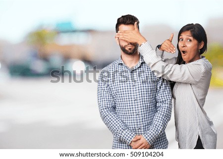 young woman giving a surprise to her boyfriend