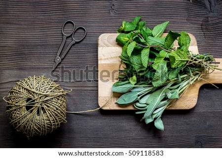 bundle of sage and thyme on wooden board top view