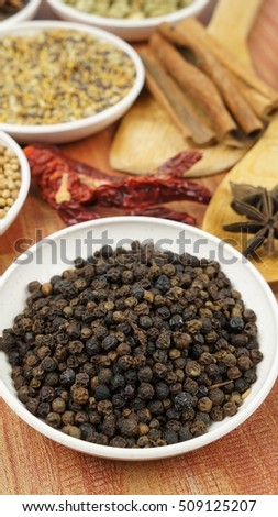 Black pepper and other spices in background