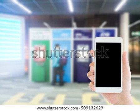 woman use mobile phone and blurred image of a man use ATM machine