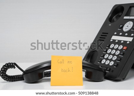 sticky note with calling back message on handset of IP phone