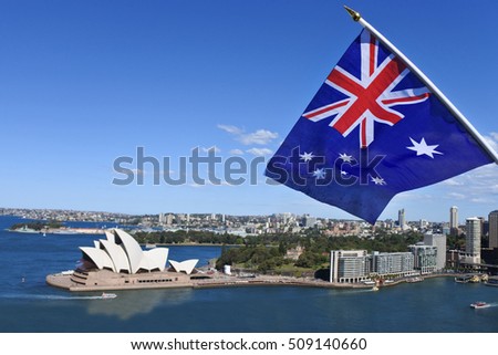 The National flag of Australia flies above Sydney Harbor and the Opera house in Sydney Australia. No people. Copy space 